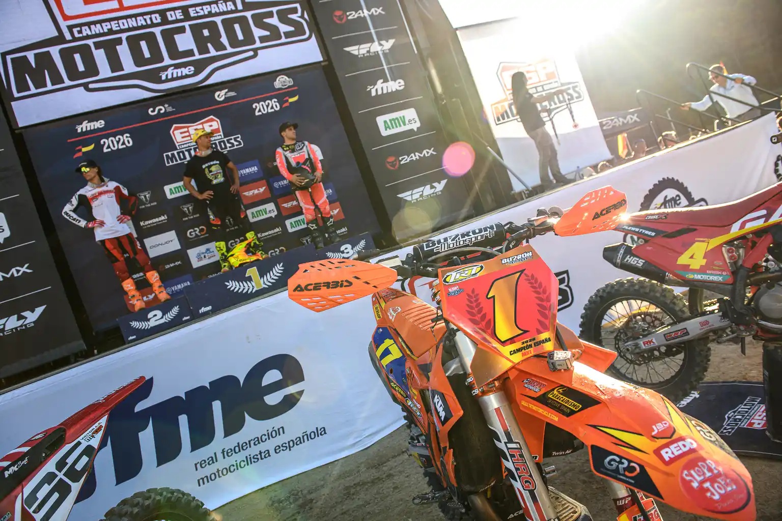 Moto de Butrón junto al podio del campeonato, con el adhesivo WP-HRG visible en la horquilla.